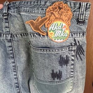 Akademiks Men’s 42 Denim Jeans with Leather Patches and Orange and Green Details